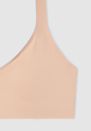 Soutien-gorge sport color pesca con una consistenza morbida e liscia, spalline larghe e un design minimalista. Realizzato in tessuto elastico e traspirante.