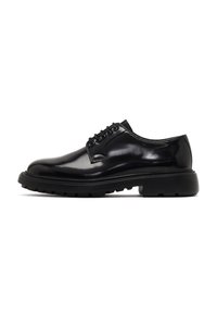 Chaussures en cuir noir avec une finition brillante, bout rond, laçage à six œillets, et semelle en caoutchouc robuste dotée de motifs de crampons profonds.