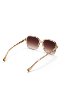 Lunettes de soleil à monture carrée avec une monture en acétate transparente accentuée de doré clair et des verres dégradés marron ; les branches fines s'étendent vers l'extérieur.