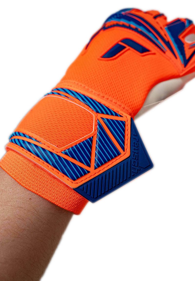 Bright orange and blue goalkeeper glove secured around wrist with textured fabric and branded adjustable strap.