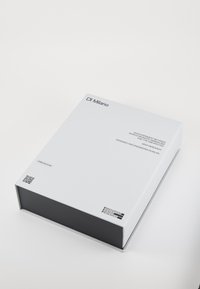 Packaging in un box bianco con finitura opaca, caratterizzato da testo nero e codici QR, che mette in mostra un design minimalista e una forma rettangolare elegante.