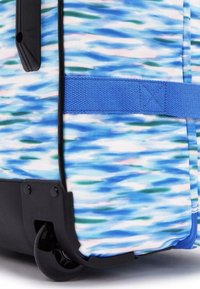 Valigia con ruote caratterizzata da un motivo ondulato blu e bianco, realizzata in materiale tessile, con accenti in plastica nera e una tracolla blu. Dotata di ruote resistenti.