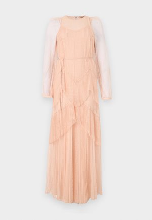 Pikk, kihiline kleit pehmest virsiku värvi kangast, millel on läbipaistvad puhvkaelused, plekitud tekstuur ja peene täppmustri. Omab talje sidumiseks rihma.