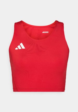 Top deportivo corto rojo con textura acanalada, que presenta un cuello redondo, tirantes anchos y detalles del logotipo en blanco.