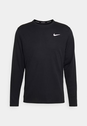 Sort langærmet Nike skjorte lavet af glat stof med et hvidt Nike-logo på venstre bryst og rund halsudskæring.