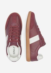 Burgundy sneakers with white stripes, made of leather and fabric. Features rounded toe and gum rubber sole with textured accents.