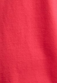 Κλείσιμο ματιών σε απαλή υφή υφάσματος σε έντονο κόκκινο χρώμα με ελαφριές σκιές και διακριτικό μοτίβο ύφανσης.