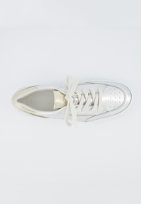 Sneaker bianca in pelle con accenti metallici, punta rotonda, lacci piatti, dettagli perforati e soletta imbottita.