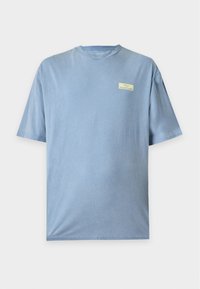 Ανοιχτό γαλάζιο T-shirt με κοντά μανίκια και στρογγυλή λαιμόκοψη με μικρό κίτρινο ορθογώνιο λογότυπο στο αριστερό στήθος που λέει "YOURTURN."