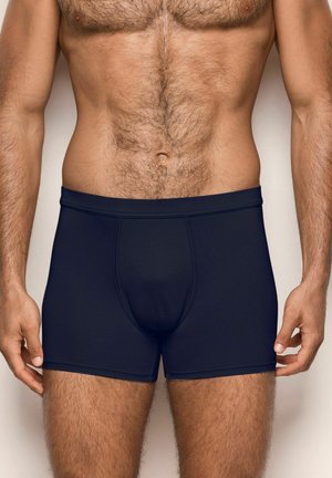 Boxers ajustados de color azul marino oscuro, fabricados en tejido elástico, con un diseño ajustado, cintura elástica y una bolsa contorneada.