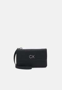 Pochette nera con polsiera, caratterizzata da un motivo a logo CK in rilievo ripetuto e iniziali CK in argento sulla cappetta frontale.