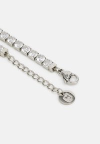 Pulseira de strass com uma corrente de metal prateada. Apresenta múltiplas pedras redondas claras ajustadas em elos de metal quadrados e um fecho tipo lagosta.