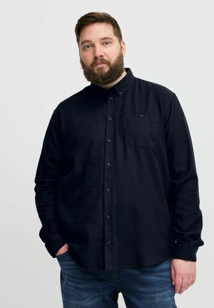 Black button-up shirt with a collar, long sleeves, and a chest pocket. Fabric appears textured with a matte finish. Worn with blue denim jeans.