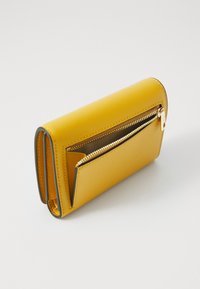 Portefeuille en cuir jaune avec une texture lisse, doté d'une poche zippée et de bords gris contrastants, dans une forme rectangulaire compacte.