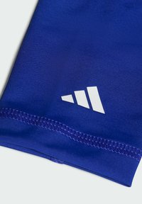 Tessuto sportivo blu con finitura testurizzata, caratterizzato da un logo a strisce gerarchiche bianche e dettagli di orlo cucito.
