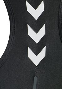 Svart atletisk bodysuit med texturerad tyg, distinkta vita chevronmönster och en slank, åtsittande form med kontrasterande detaljer.