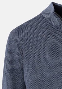 Texturerad marinblå tröja med halvdragkedja, med stickad tyg och strukturerad form. Lämplig för att bära i lager eller för avslappnad användning.