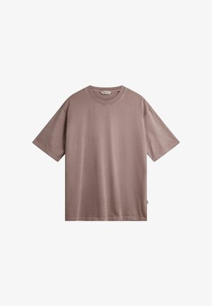 T-shirt mauve pâle en coton doux avec une coupe décontractée. Il présente des manches courtes et un col rond. Aucun motif ni accent n’est visible.
