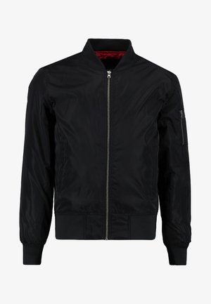 Fekete bomberdzseki cipzárral az elején, bordázott mandzsettákkal és aljjal, sima külső felülettel. Piros bélés és cipzáras zseb található az ujjon.