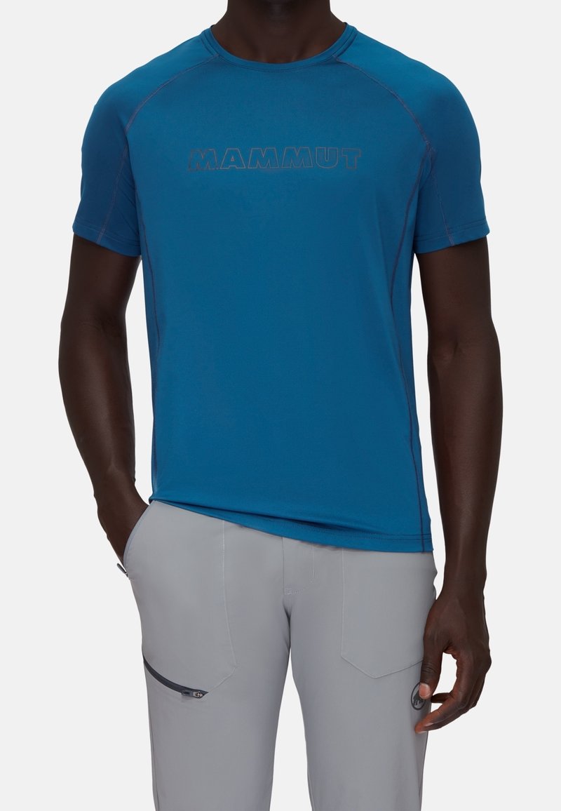 Blå, kortärmad teknisk skjorta med "MAMMUT"-logotyp i en mörkare nyans och raglanärmar. Slät tyg med en lätt lyster och stretch.