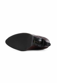 Suola di scarpa in pelle marrone con fondo in gomma nera testurizzata, caratterizzata da una forma affusolata e un tacco piccolo. Contrassegnata con dettagli sulla taglia e sul modello.