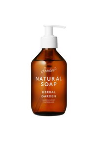 Bottiglia a pompa in vetro marrone di sapone naturale; pompa bianca con tappo rigato; l'etichetta riporta "Sapone Naturale Giardino Erbaceo, Fatto a Zurigo."
