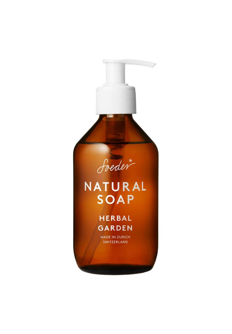 Bottiglia a pompa in vetro marrone di sapone naturale; pompa bianca con tappo rigato; l'etichetta riporta "Sapone Naturale Giardino Erbaceo, Fatto a Zurigo."