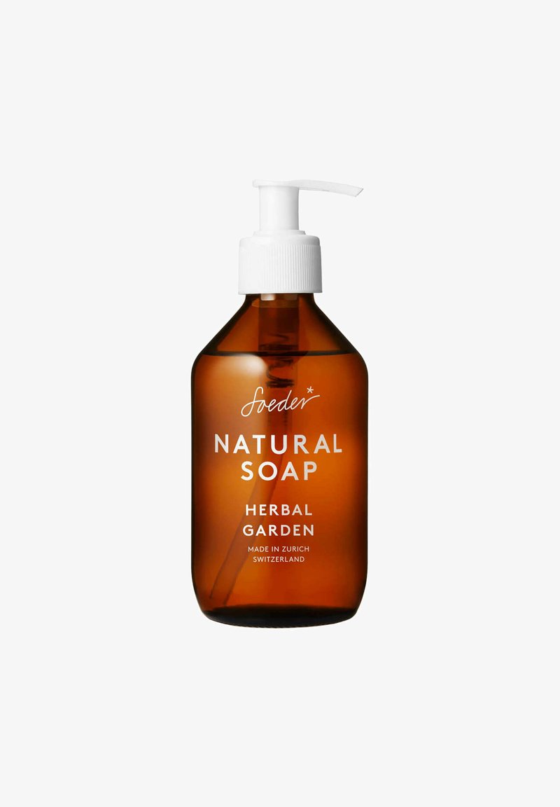 Bottiglia a pompa in vetro marrone di sapone naturale; pompa bianca con tappo rigato; l'etichetta riporta "Sapone Naturale Giardino Erbaceo, Fatto a Zurigo."