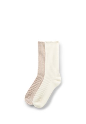 Paar gerippte Sneakersocken, eines beige und eines cremeweiß, flach auf weißem Hintergrund ausgelegt.