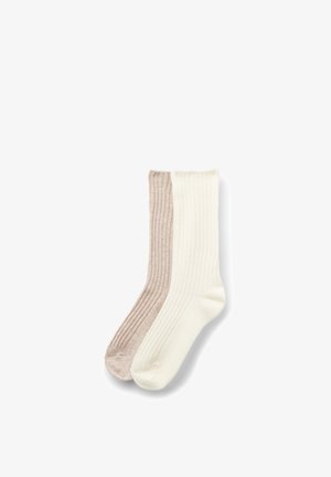 Paar gerippte Sneakersocken, eines beige und eines cremeweiß, flach auf weißem Hintergrund ausgelegt.