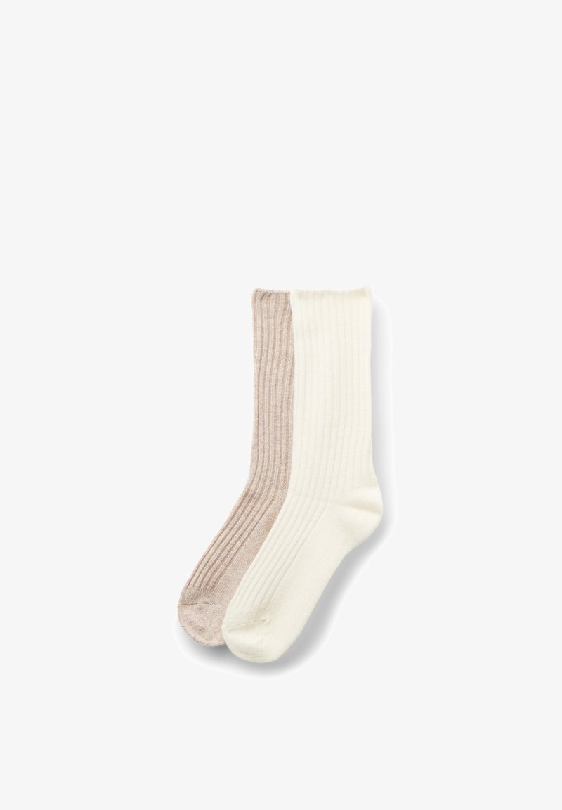 Paire de chaussettes à côtes, une beige et une blanc cassé, étalées à plat sur un fond blanc.