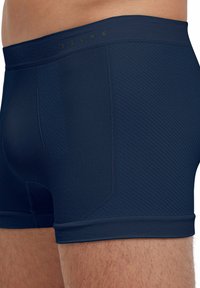 Boxers bleu marine avec un design sans couture, présentant un motif diagonal texturé et une taille élastique avec le logo "FALKE".