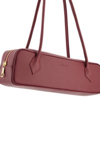 Burgundy leather handbag with a rectangular shape, zip closure, and two handle straps. Features subtle branding and minimal hardware accents.