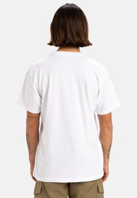 Camiseta de algodón blanca, de manga corta, cuello redondo, corte relajado, textura suave, diseño simple, sin patrones ni gráficos visibles.