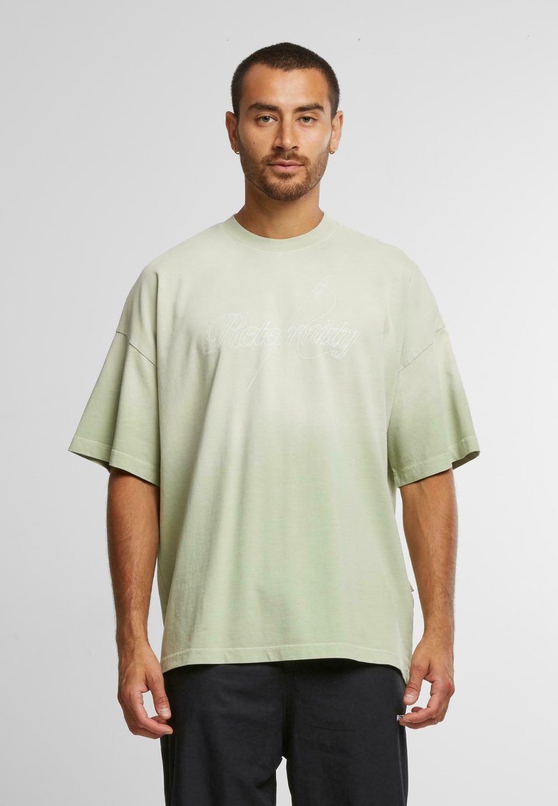 Lys grøn oversized t-shirt lavet af blødt stof, med korte ærmer og rund halsudskæring. Der er vist skriftsprog på forsiden.