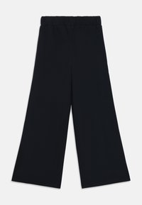 Sorte vide bukser laget av myk stoff, med elastisk midjebånd og en glatt tekstur, med et rent, minimalistisk design.