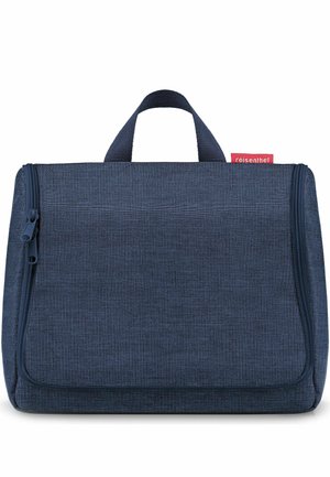 Compatta borsa da viaggio per prodotti da toilette di colore blu navy, con doppia cerniera, maniglia superiore e piccola etichetta rossa sul lato.