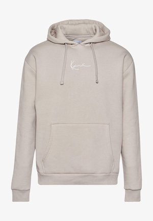 Béžová mikina s kapucňou, predným vreckom, šnúrkami a malým bielym logom na hrudi. Mäkka tkanina s rebrovanými manžetami a spodným lemom.