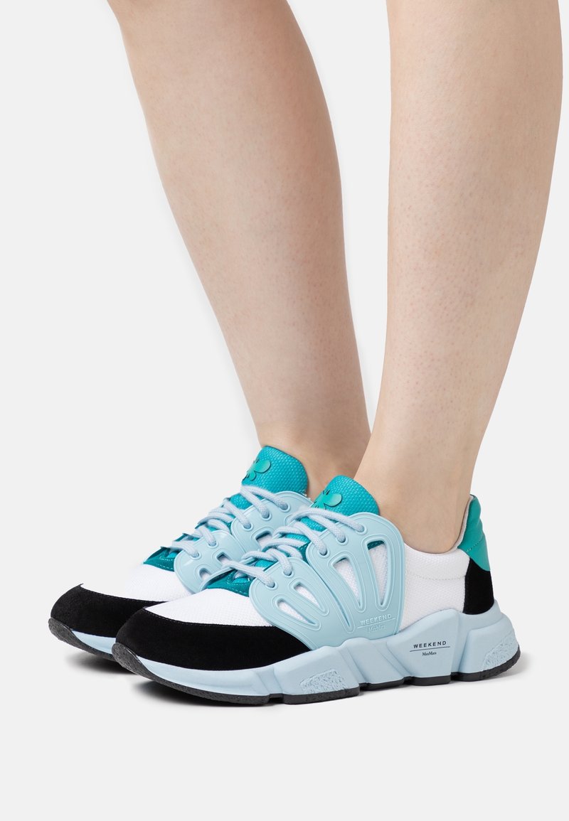 Le sneakers presentano una tomaia in rete leggera di colore bianco, arricchita con dettagli turchesi e neri. Un design unico della fascia laterale offre supporto.