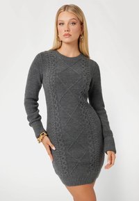 Vestito grigio lavorato a maglia con maniche lunghe, caratterizzato da motivi a treccia e una silhouette aderente. Texture liscia, polsini e orlo a costine.