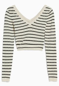 Virkat kort topp i krämfärg med svarta zigzag-mönster. Har långa ärmar och en bred V-ringning. Mjuk textur genom hela plagget.