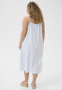 Abito senza maniche di un blu chiaro, con una vestibilità comoda, realizzato in tessuto morbido, con schiena arricciata e lunghezza fino al polpaccio.