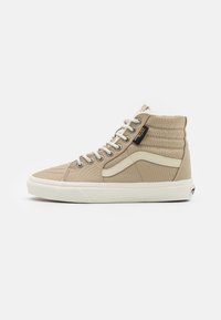 Beige høyhalset sneaker laget av strukturert lerret med hvit gummisåle. Har grå serde accenter og metalliske snørehull.