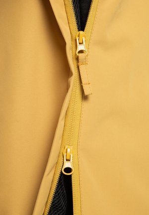 Tissu jaune avec une finition lisse, doté d'une double fermeture éclair de couleur assortie et d'une doublure en maille noire visible par l'ouverture.