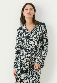 Abito camicia a maniche lunghe in navy, crema e leggero blu con motivo floreale, caratterizzato da un colletto e una cintura in vita.