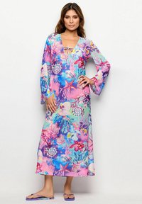 Lange bloemenjurk met klokmouwen, met een kleurrijk zeethema patroon in roze, blauw en groene tinten. Lichtgewicht stof en een relaxte pasvorm.