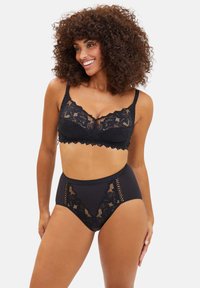 Bralette en dentelle noire avec des bords festonnés et des bretelles ajustables, accompagné de culottes taille haute avec des accents en dentelle et une finition lisse.