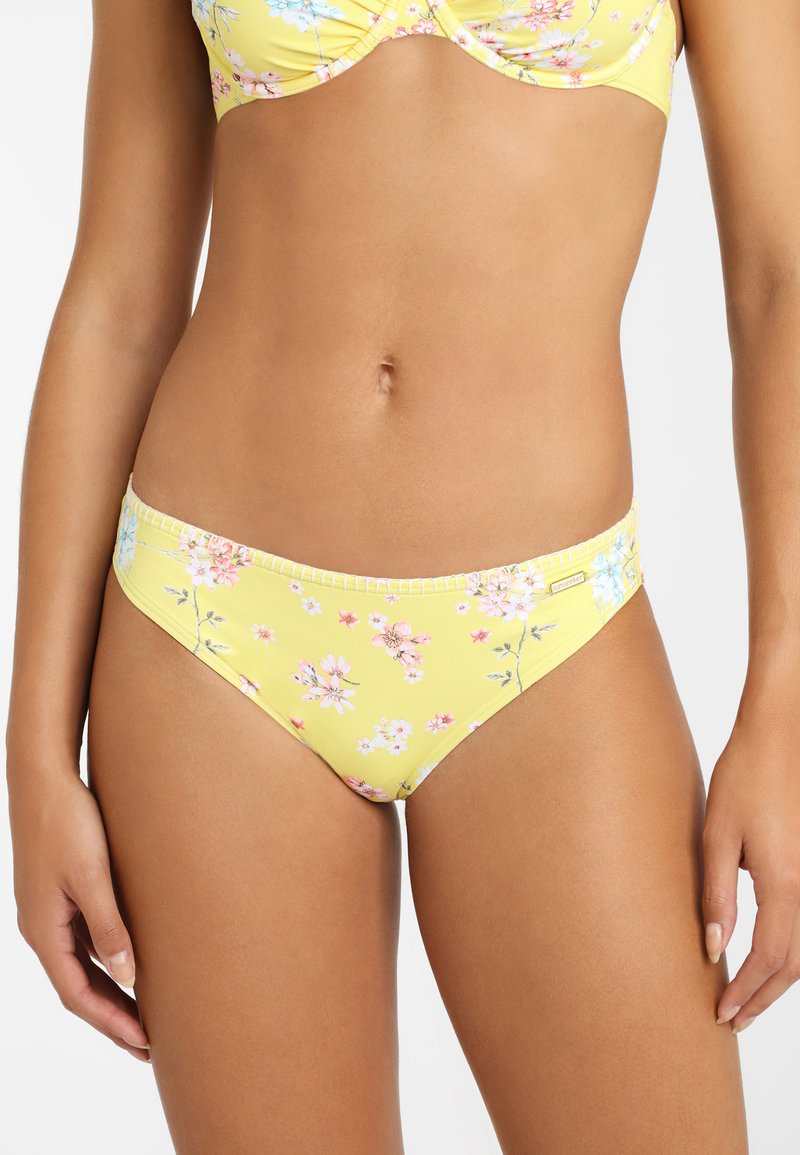 Gelber Bikiniunterteil mit einem floralem Druck in Pink und Blau. Er zeichnet sich durch eine glatte Textur und einen moderaten Schnitt mit einem genähten Taillenbund aus.
