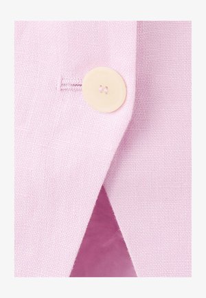 Prim-plan al unui nasture crem cusut pe țesătură de in roz deschis cu o gaură pentru nasture, evidențiind textura și detaliile cusăturii.