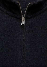 Czarny sweter na zamek z żeberkowym wzorem, z wysokim kołnierzem i srebrnymi detalami zamka z przodu. Miękki materiał dziany.